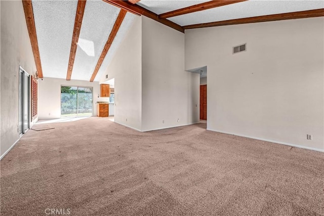 unfurnished living room featuring visible vents, carpet, beamed ceiling, and high vaulted ceiling