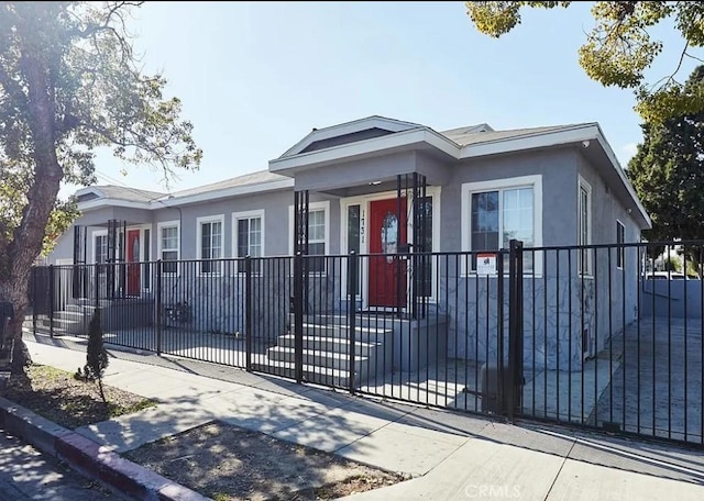 view of front of property with a fenced front yard and stucco siding