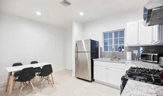 kitchen featuring backsplash, visible vents, white cabinets, and appliances with stainless steel finishes