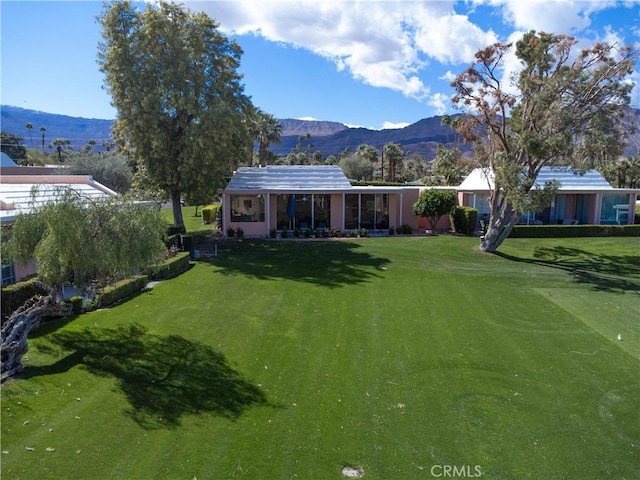 exterior space featuring a lawn and a mountain view