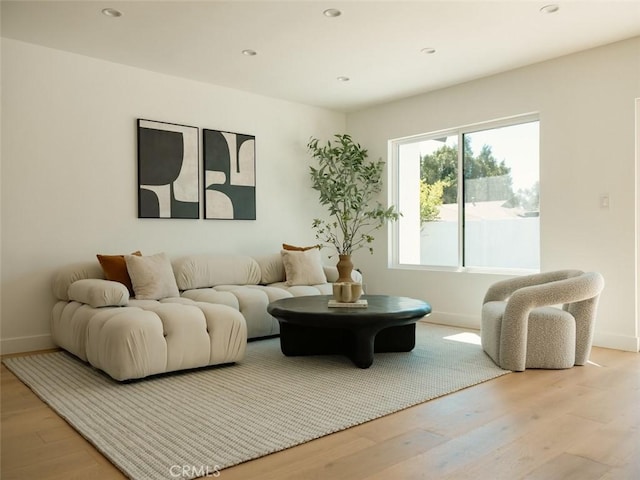 living room with recessed lighting, baseboards, and light wood finished floors