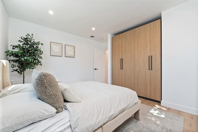 bedroom featuring recessed lighting, light wood-type flooring, baseboards, and visible vents