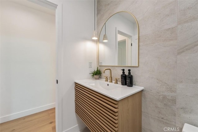 bathroom with baseboards, wood finished floors, and vanity