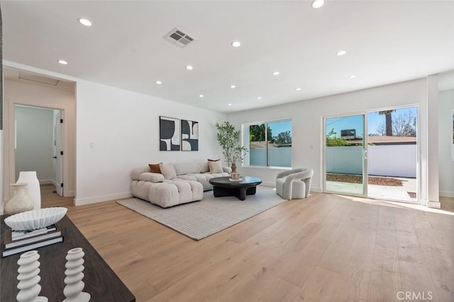 living area featuring light wood-style flooring, recessed lighting, visible vents, and baseboards