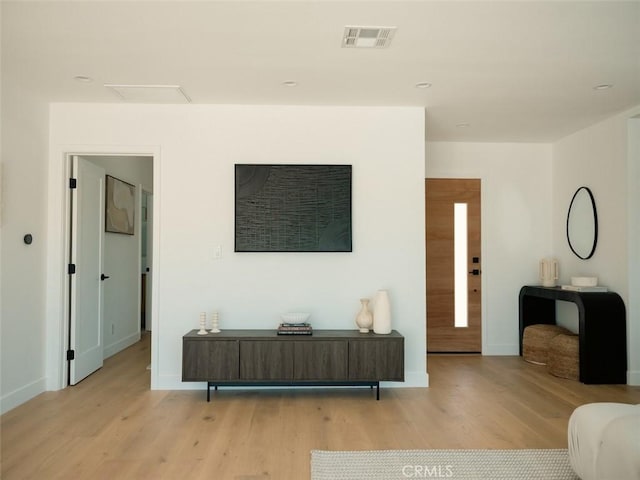 living room with visible vents, baseboards, and light wood-style floors