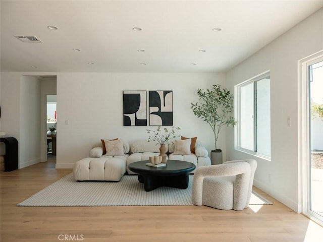 living room featuring recessed lighting, visible vents, baseboards, and wood finished floors