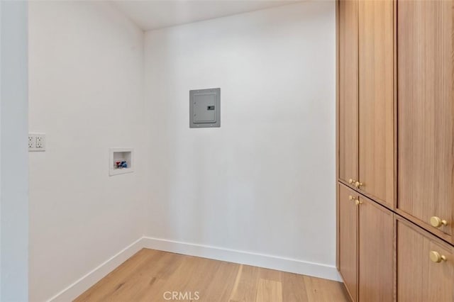 washroom with hookup for a washing machine, cabinet space, baseboards, and light wood finished floors