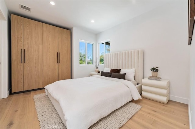 bedroom with light wood-type flooring, visible vents, baseboards, and recessed lighting