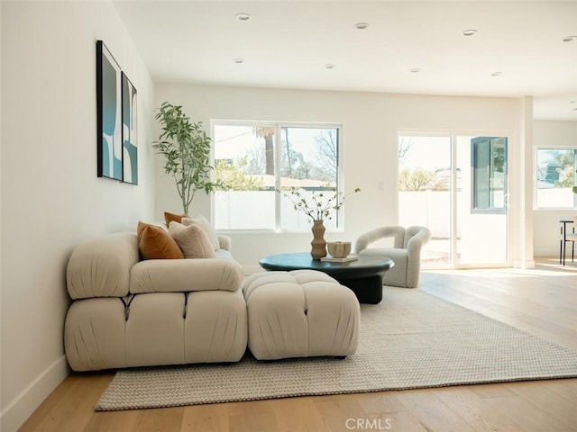 living area with recessed lighting, wood finished floors, and baseboards