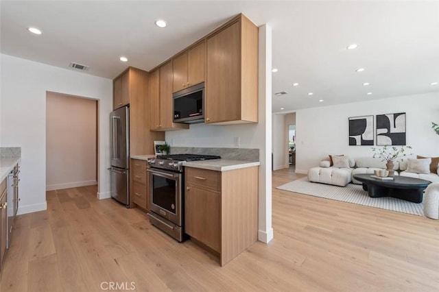 kitchen featuring visible vents, high quality appliances, light wood-style flooring, recessed lighting, and light countertops