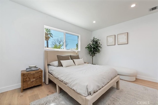 bedroom with recessed lighting, wood finished floors, and baseboards