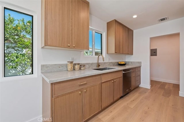 kitchen featuring visible vents, a sink, light wood finished floors, baseboards, and dishwasher