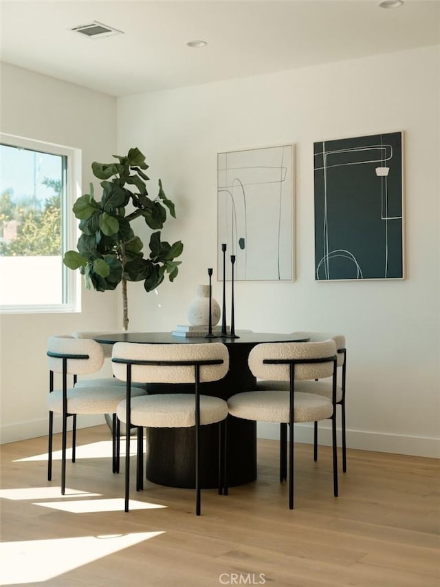 dining space featuring visible vents, wood finished floors, and baseboards