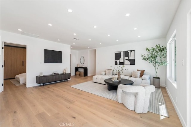 living room featuring light wood-style flooring, recessed lighting, and baseboards