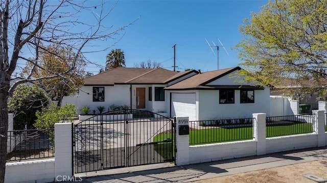 ranch-style home featuring a garage, a fenced front yard, and stucco siding