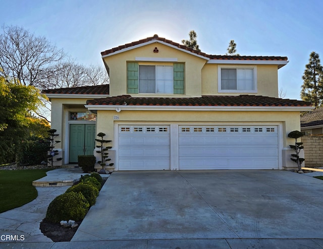 view of front facade with concrete driveway, a tiled roof, a garage, and stucco siding