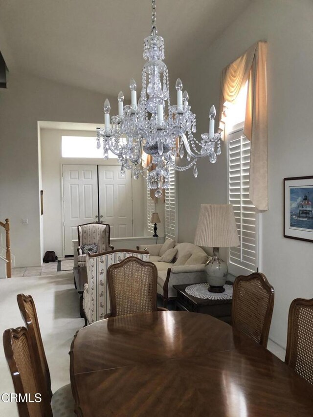 dining area with an inviting chandelier and vaulted ceiling