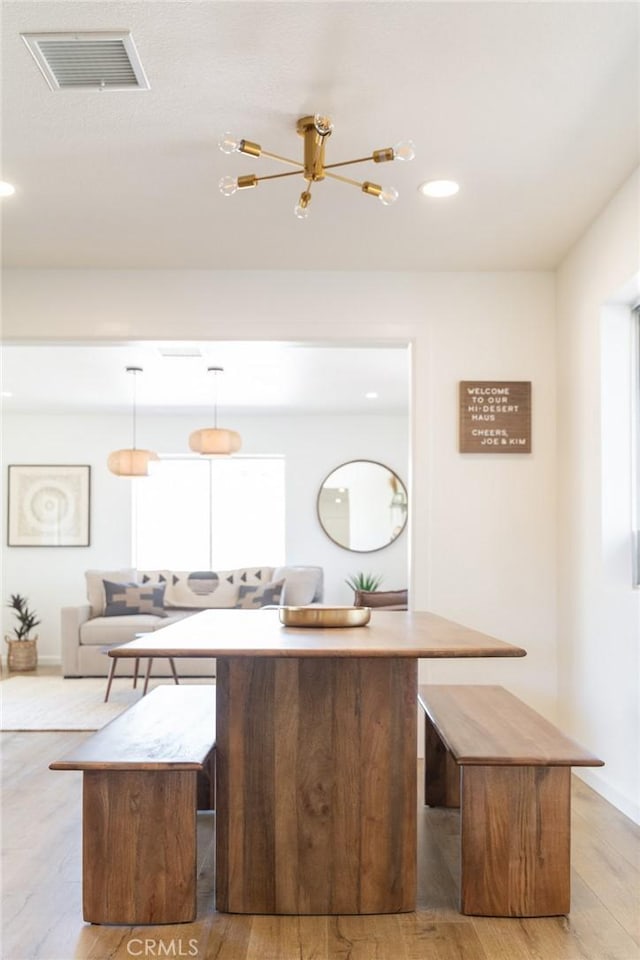 kitchen featuring visible vents, baseboards, light wood-type flooring, recessed lighting, and a kitchen breakfast bar