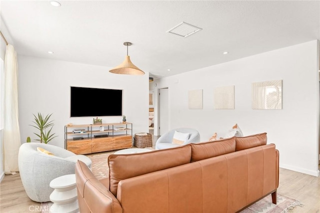 living room featuring light wood finished floors, visible vents, recessed lighting, and baseboards