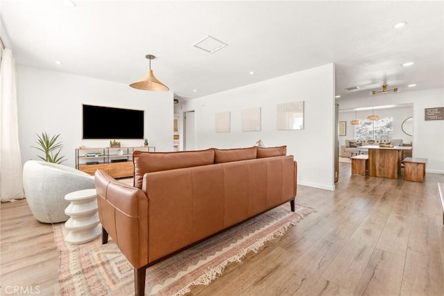 living area with light wood finished floors, visible vents, recessed lighting, and baseboards