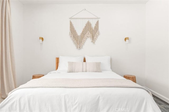 bedroom featuring baseboards and wood finished floors