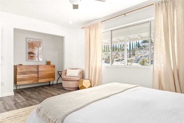 bedroom featuring ceiling fan, baseboards, and wood finished floors