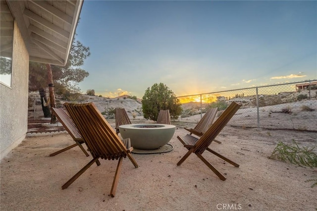 patio terrace at dusk with a fire pit and fence