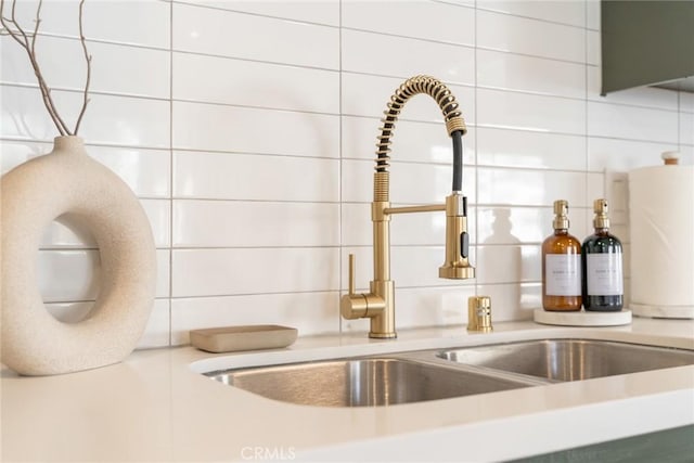 details with light countertops, backsplash, and a sink