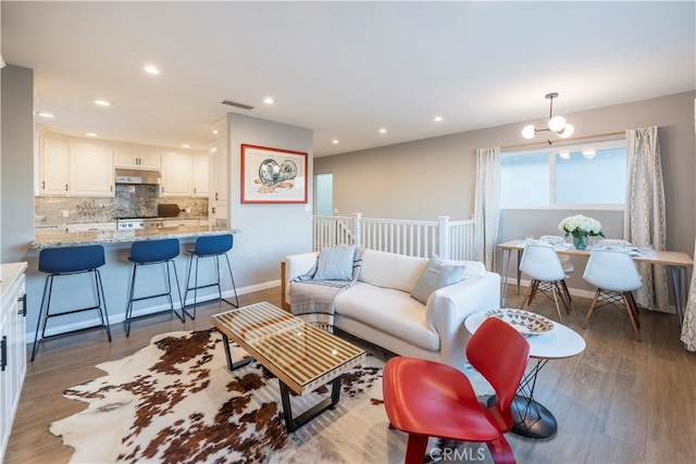 living room featuring visible vents, recessed lighting, and wood finished floors