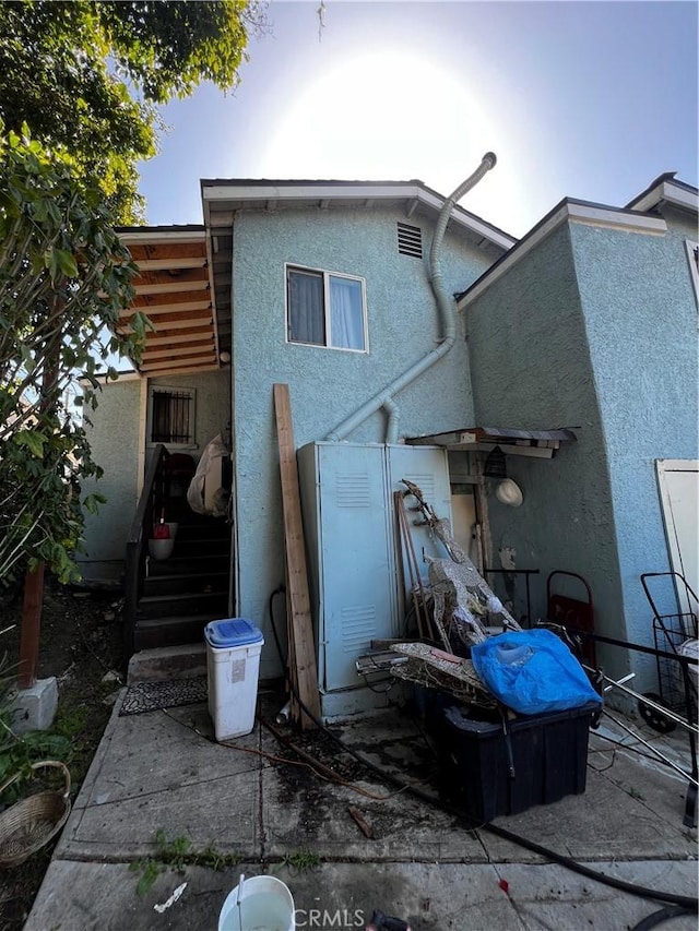 rear view of property featuring stucco siding