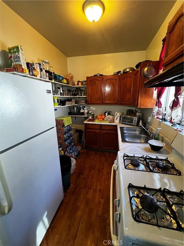 kitchen featuring a sink, dark wood-type flooring, light countertops, white appliances, and open shelves