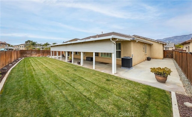 back of house with a patio area, a lawn, a fenced backyard, and stucco siding