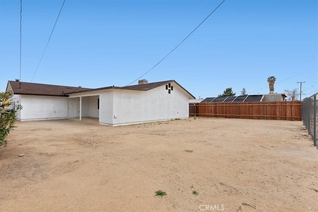 back of house with stucco siding and a fenced backyard