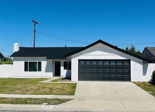 view of front of house with concrete driveway, a garage, and a front yard