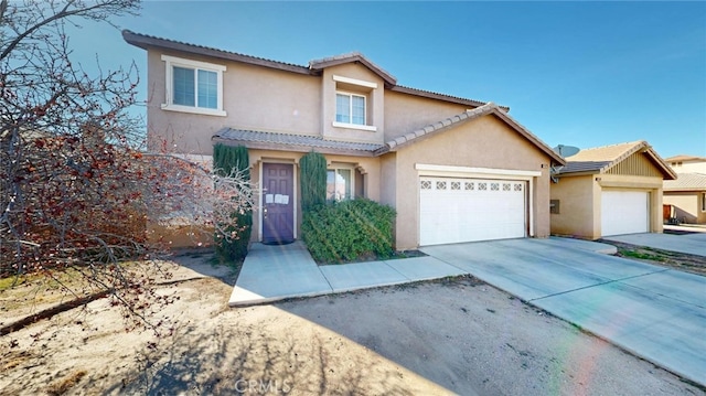 view of front of property featuring a tiled roof, stucco siding, an attached garage, and concrete driveway