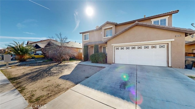 traditional-style home with an attached garage, driveway, and stucco siding