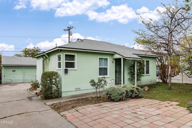 bungalow-style house with roof with shingles, stucco siding, an outbuilding, fence, and crawl space