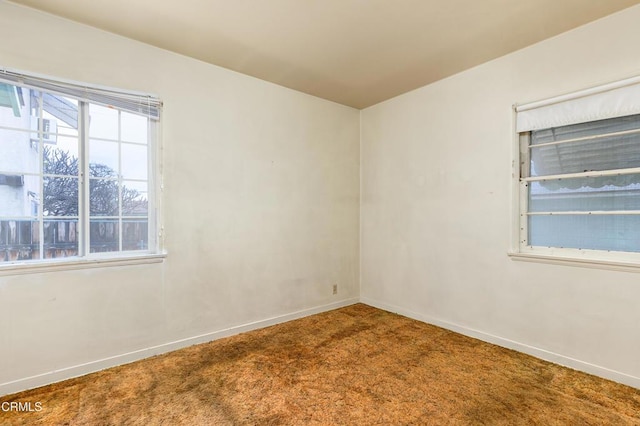 carpeted empty room with baseboards