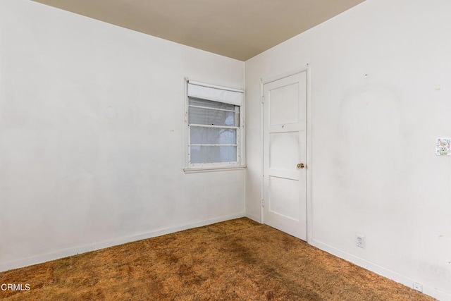 carpeted empty room featuring baseboards