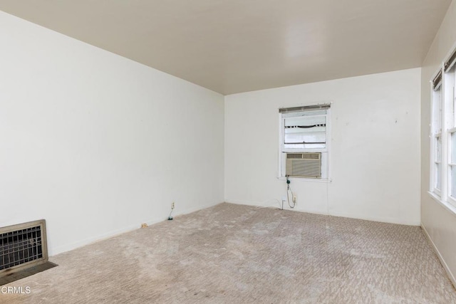 carpeted spare room featuring visible vents and cooling unit