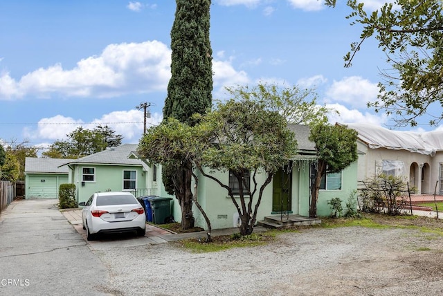 view of front of home featuring driveway, stucco siding, and fence