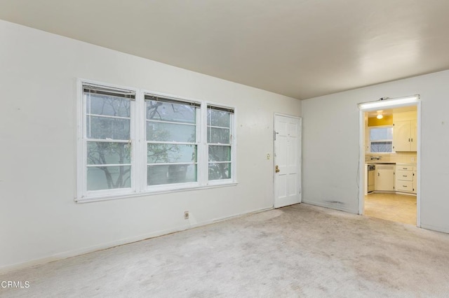 spare room with plenty of natural light and light colored carpet