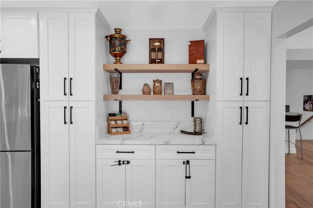 bar featuring freestanding refrigerator and wood finished floors