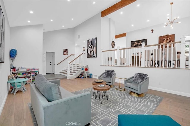 living area featuring stairway, wood finished floors, high vaulted ceiling, an inviting chandelier, and beamed ceiling