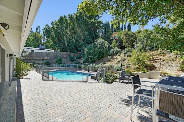 view of swimming pool with a patio area, a fenced in pool, and fence