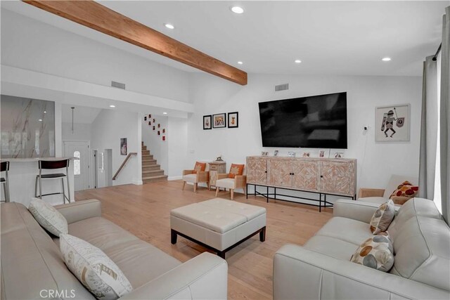 living room featuring lofted ceiling with beams, stairway, light wood-type flooring, and recessed lighting