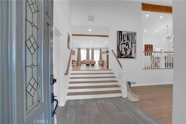 entrance foyer featuring visible vents, a chandelier, stairway, recessed lighting, and wood finished floors