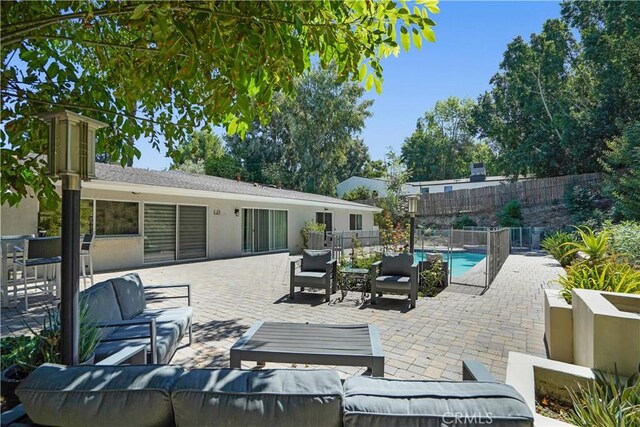 view of patio / terrace with outdoor lounge area, fence, and a fenced in pool