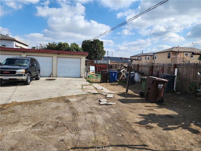 view of yard featuring an outbuilding, a garage, and fence