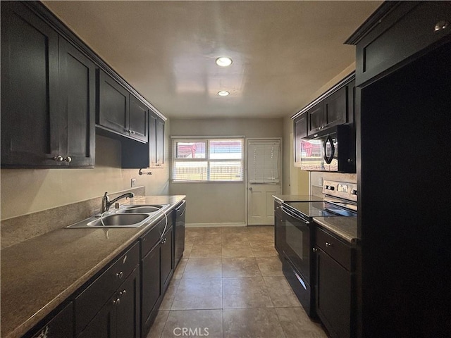 kitchen with dark cabinetry, black appliances, light tile patterned floors, and a sink